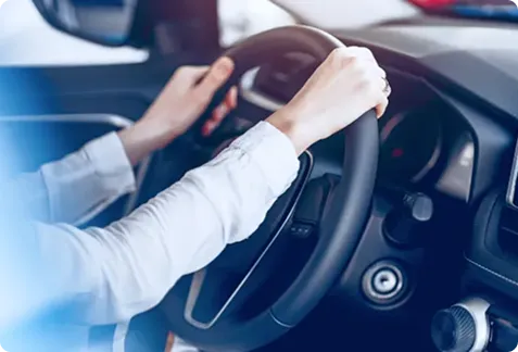 車のハンドルを両手で握って運転する様子